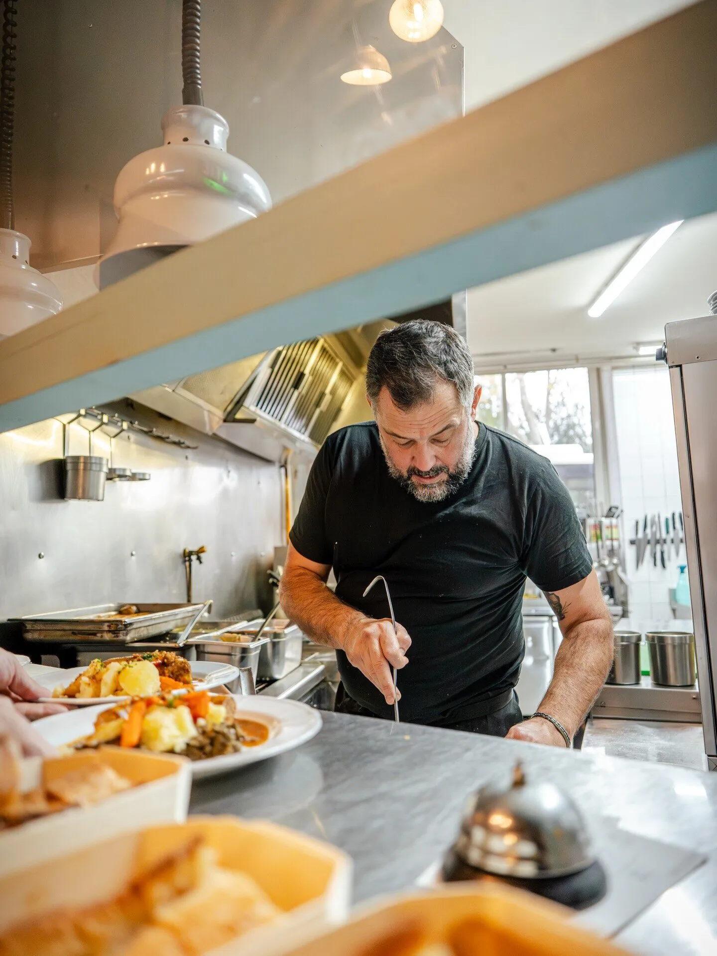 Le chef dresse une assiette au passe de la cuisine