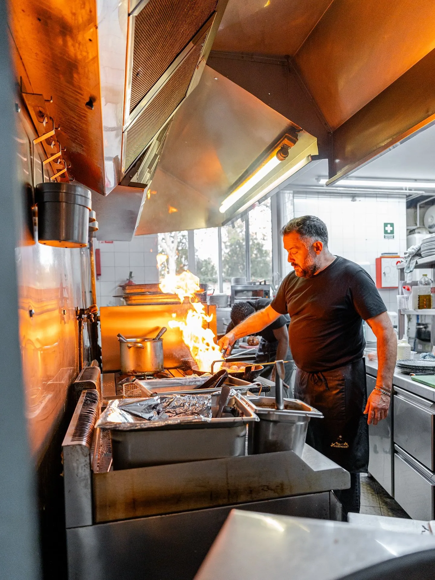 Le chef flambe une poêle en cuisine, chez Aux Phils des Saveurs à Lyon 8e