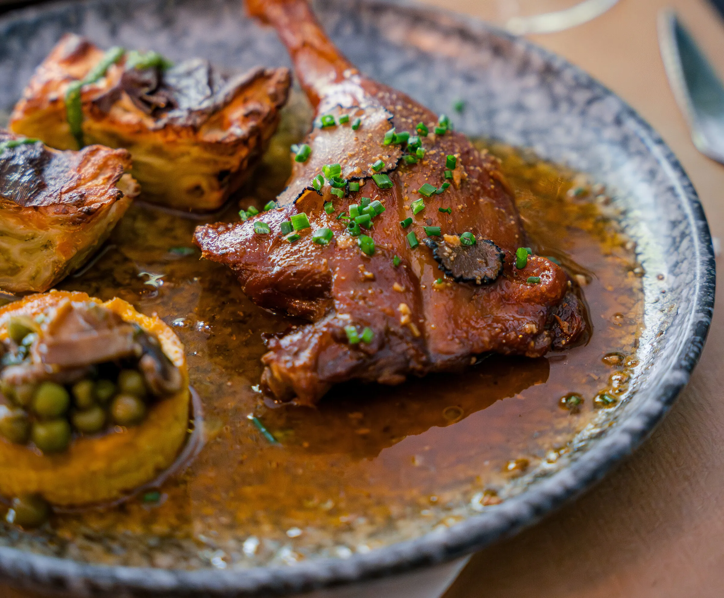 Cuisse de canard confite au jus truffé et gratin de ravioles