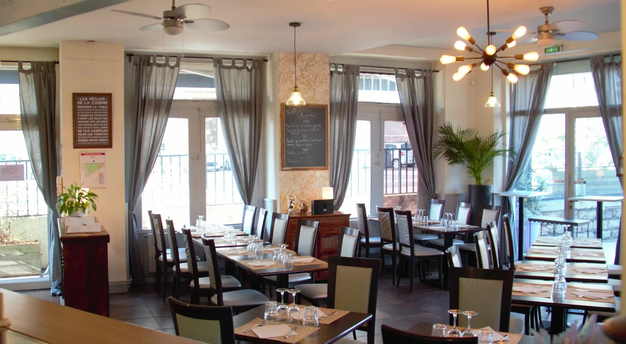 La salle du bistrot et ses grandes fenêtres